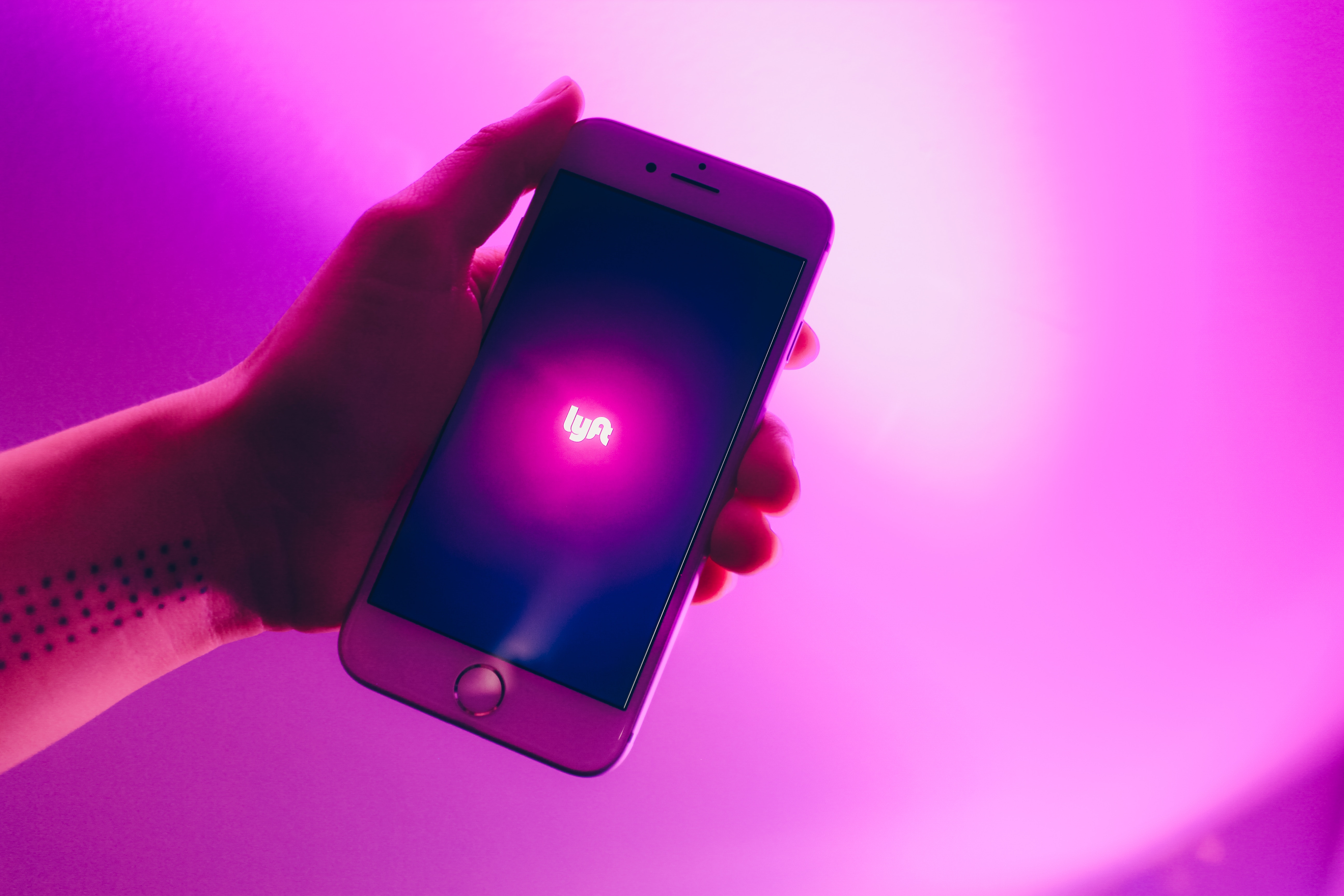 Photo of a person holding a cellphone with the word Lyft on it