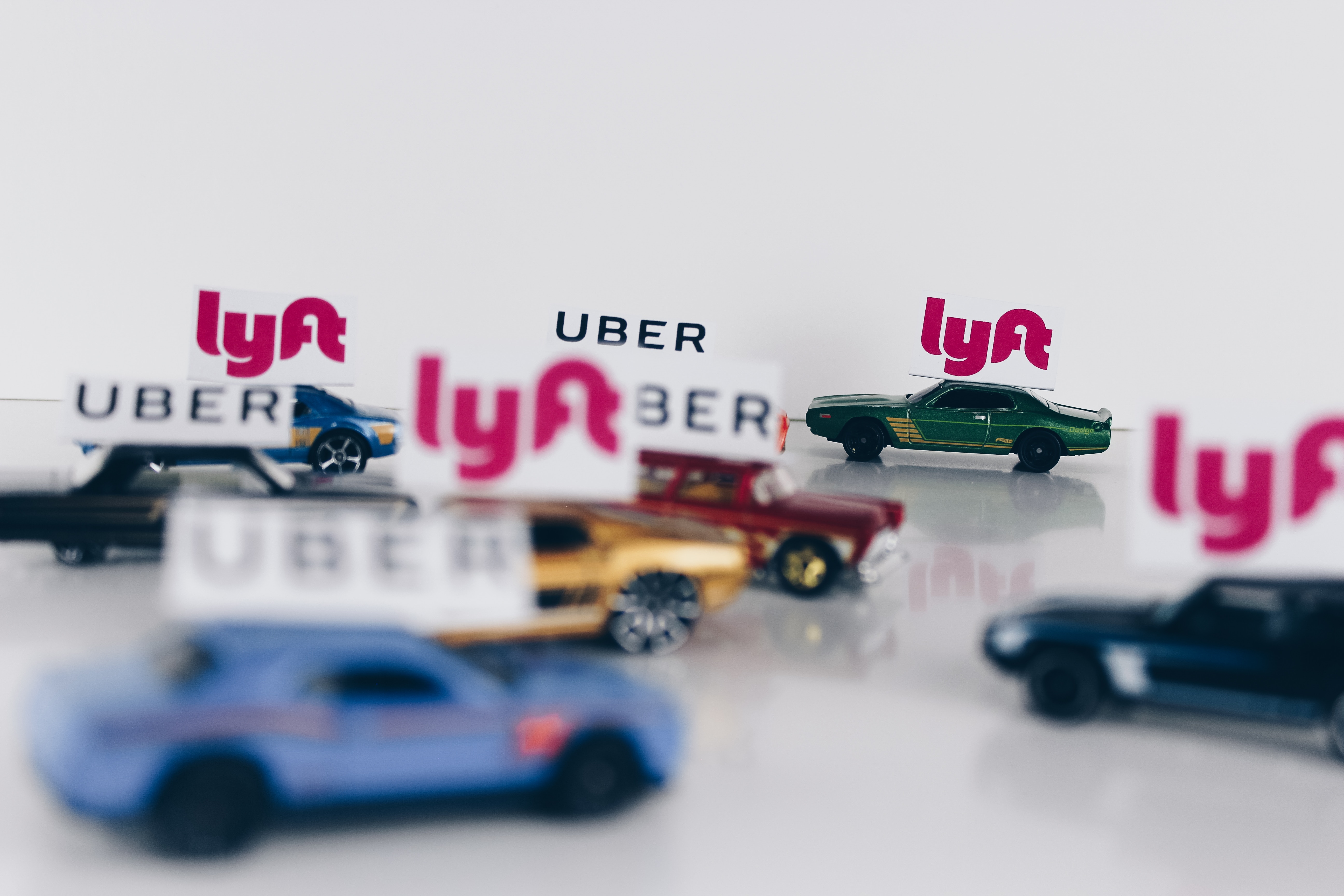 Picture of Several Toy Cars with Uber and Lyft Signs on top of each car